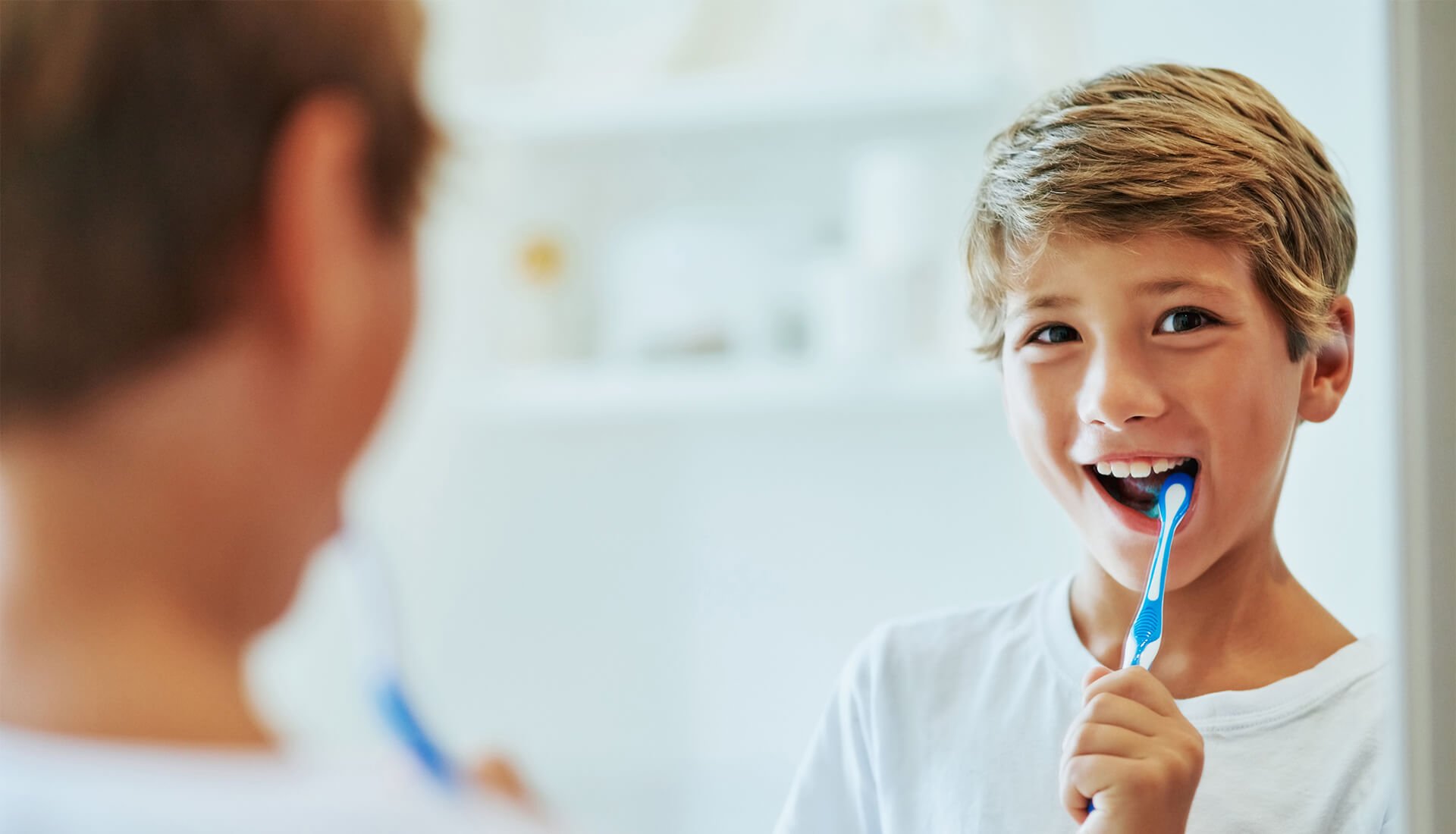 young boy brushing his teeth